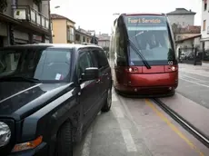 A sinistra il tram bloccato da un suv in via Ca’ Rossa Sopra il marciapiede rotto alla fine di via Cappuccina vicino alla fermata di via Sernaglia. Sotto ancora auto che transitano sui binari e alcuni cittadini che commentano il prossimo avvio del servizio tram Domenica l’inaugurazione, lunedì l’avvio