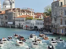 The boat carrying George Clooney and his wife Amal Alamuddin, is surrounded by media and security boats as they cruise the Grand Canal after leaving the Aman luxury Hotel in Venice, Italy, Sunday, Sept. 28, 2014. George Clooney married human rights lawyer Amal Alamuddin Saturday, the actor's representative said, out of sight of pursuing paparazzi and adoring crowds. (AP Photo/Luigi Costantini)