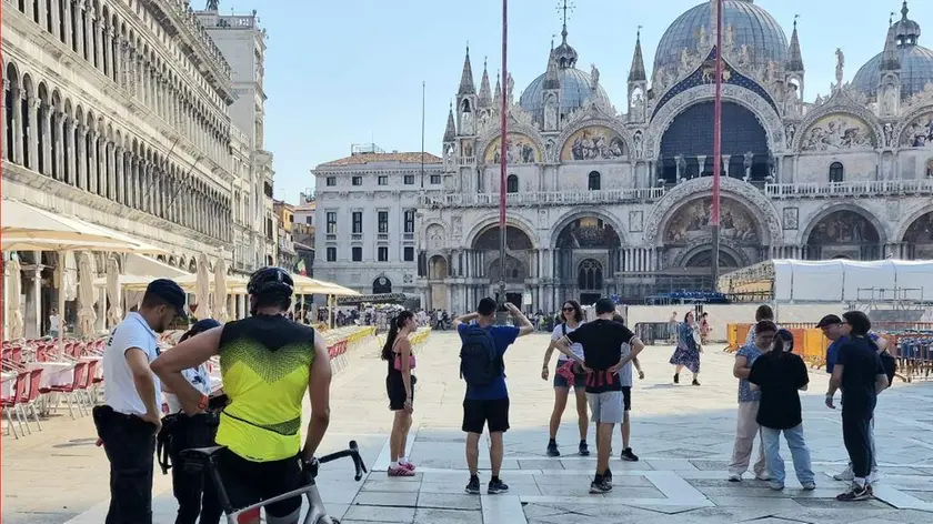 Il turista con la bicicletta a mano fermato in piazza San Marco