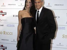 George Clooney and his fiancee Amal Alamuddin pose for photographers as they arrive for the "Celebrity Fight Night" foundation gala dinner, in Florence, Italy, Sunday, Sept. 7, 2014. (AP Photo/Francesco Bellini)