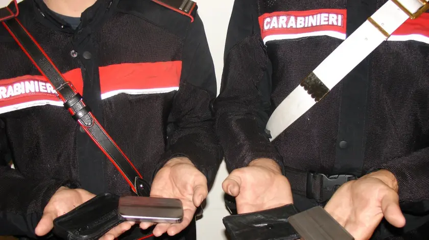 Due carabinieri mostrano le lastre di metallo vendute da un napoletano fingendo fossero l'ultimo modello di I-Phone 4, Roma, 6 ottobre 2011. ANSA / UFFICIO STAMPA CARABINIERI+++NO SALES - EDITORIAL USE ONLY++++