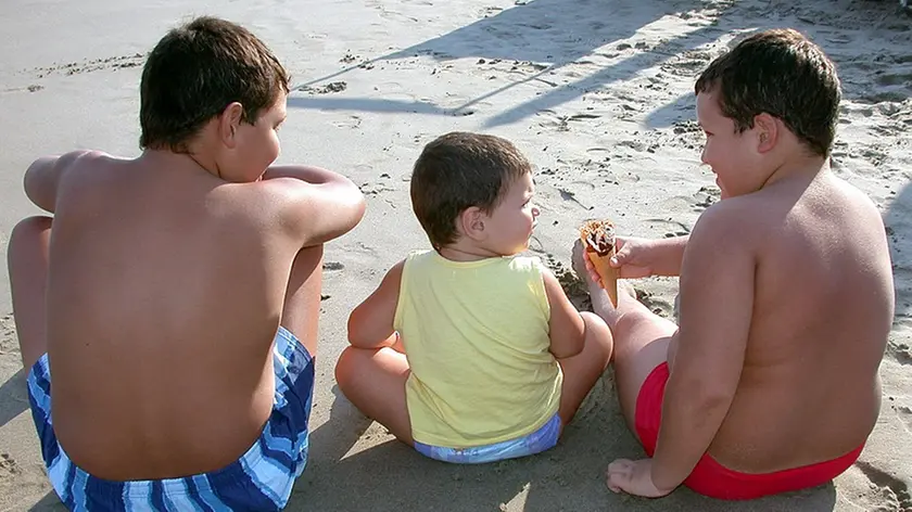 OBESITA':PICCHI A SUD,ATTESA VITA BIMBI MINORE GENITORI..Tre bambini seduti in riva al mare su una spiaggia ligure in un'immagine d'archivio senza data. A Sud si registrano i picchi di obesita', l'attesa di vita dei bambini e' minore di quella dei genitori...SILVIO FASANO/GID