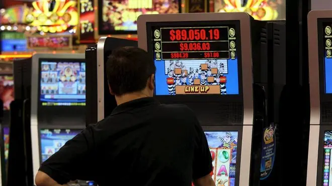 Un uomo gioca con una slot machine in una foto d'archivio. ANSA / YM YIK .