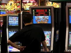 Un uomo gioca con una slot machine in una foto d'archivio. ANSA / YM YIK .