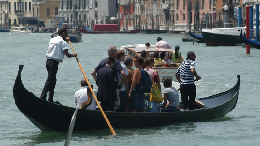 Gondolieri traghettano residenti e turisti dallo stazio di Santa Sofia a Rialto, in un'immagine di repertorio. Servizio pubblico dimezzato al Traghetto di Santa Sofia, punto di imbarco sul Canal Grande, perche' ad una gondola mancano due remi: a causa dei mancati finanziamenti, infatti, il Comune di Venezia per due anni non ha potuto erogare sufficienti risorse all'Ente Gondola, la societa' che gestisce il traghettamento (o 'parada') su gondola da riva a riva del 'Canalazzo' e la manutenzione delle relative strutture. Pertanto, per una decina di giorni, funzionera' una sola gondola delle due che normalmente da Santa Sofia fanno la spola tra il Sestiere di Cannaregio e il Mercato di Rialto: la seconda e' rimasta senza remi. ANSA/ANDREA MEROLA
