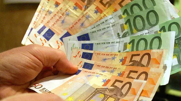 Un uomo tiene in mano alcune banconote di Euro, in una immagine di archivio. ANSA/ETTORE FERRARI/DRN